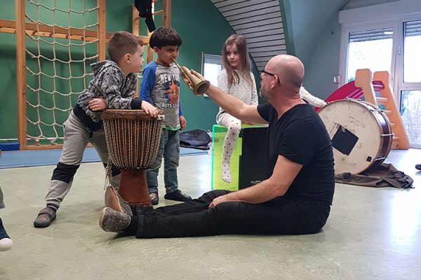 Ein Musikpädagoge führt Kinder spielerisch in die Musik ein.